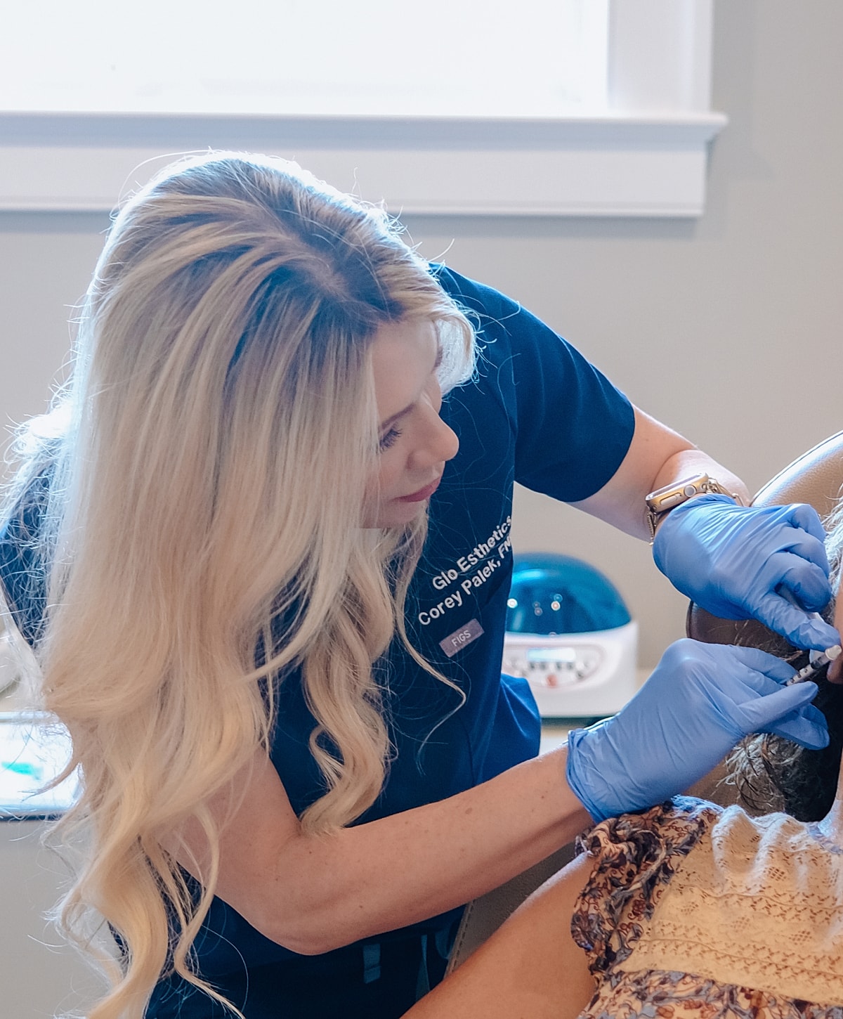 Esthetician providing treatment to a client.