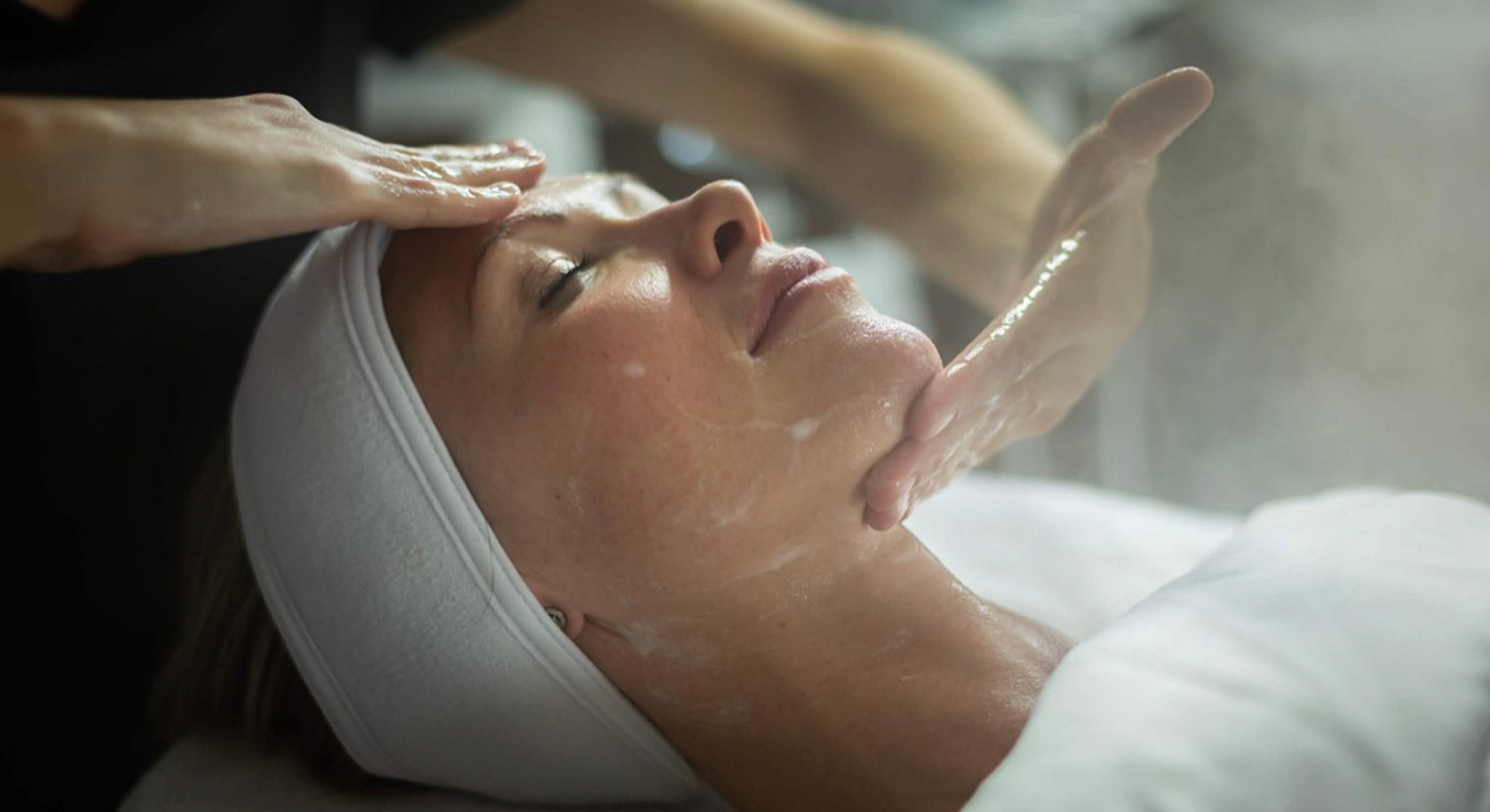Facial massage and skincare treatment in progress.