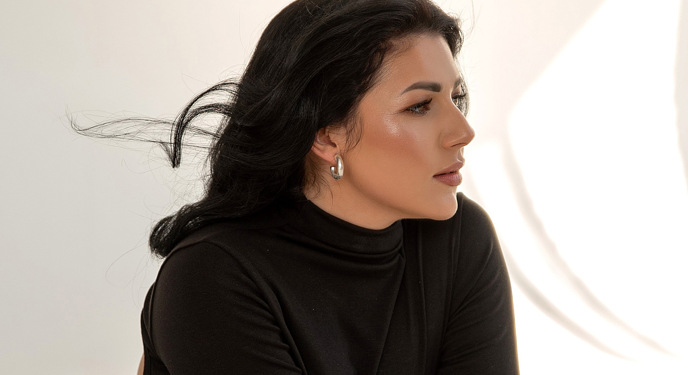 Woman in profile with flowing hair, natural light.