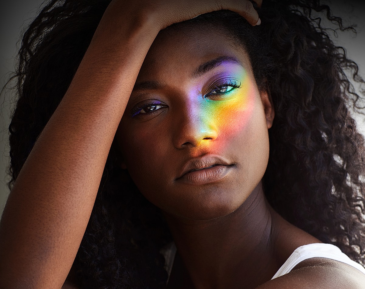 Woman’s face with colorful light reflection.