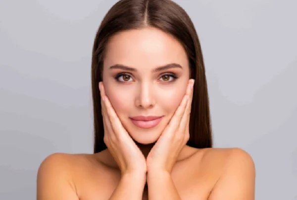 Woman with flawless skin cupping her face after EZ Gel in Far Hills, NJ against a neutral background.